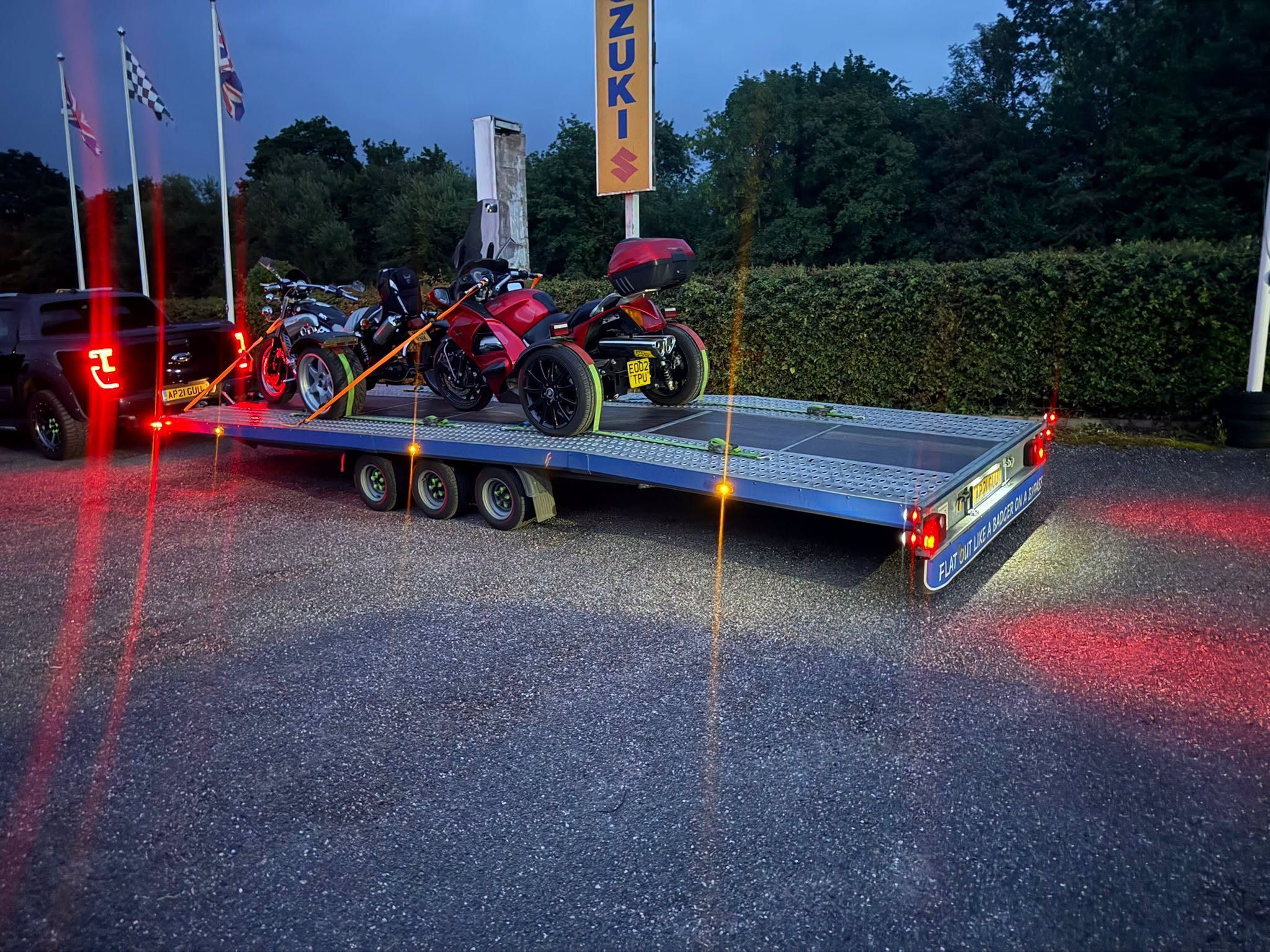 Trikes secured on a flatbed trailer for evening transport